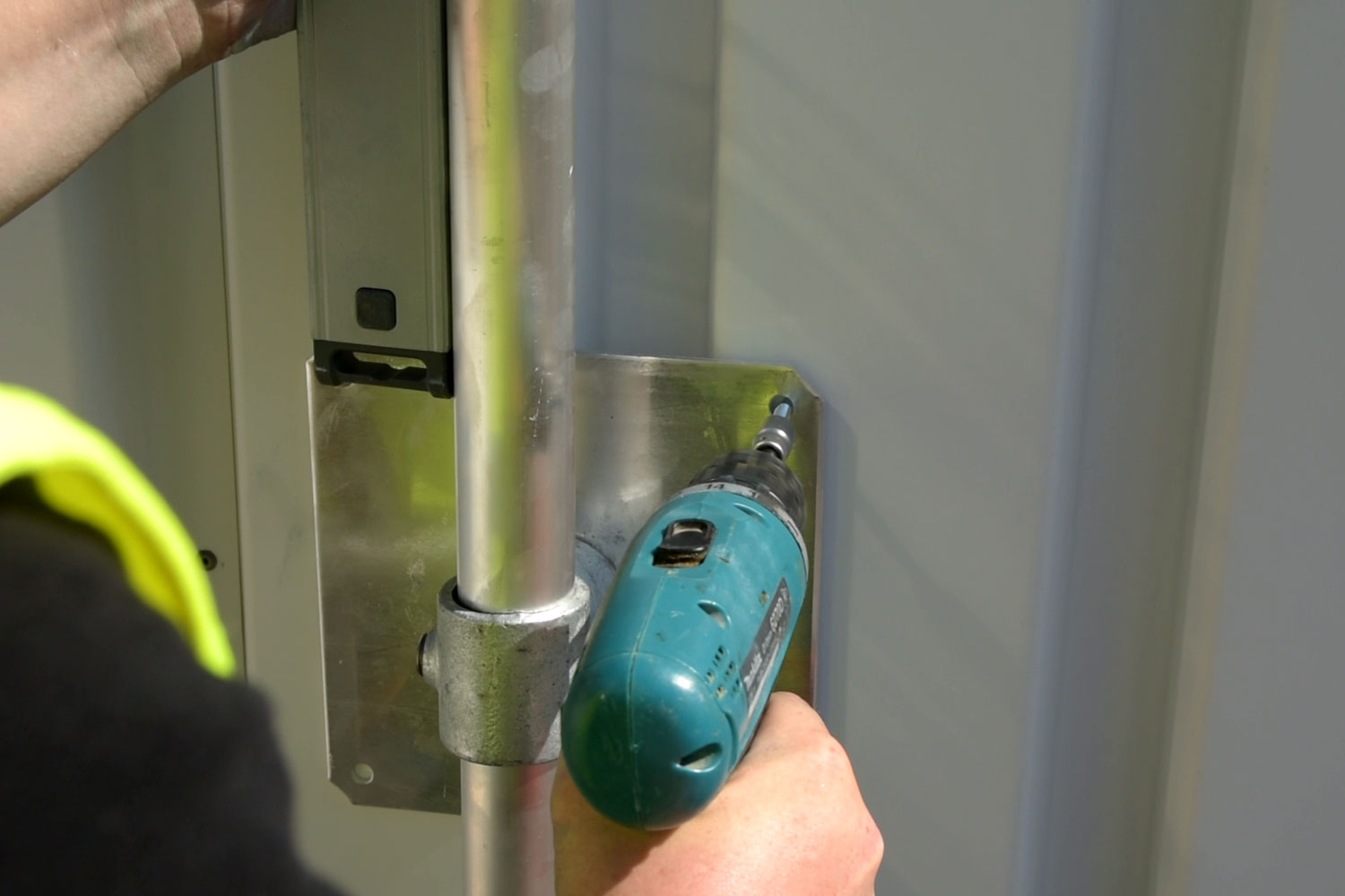 Befestigung einer Halterplatte am Untergrund mit Werkzeug während der Montage