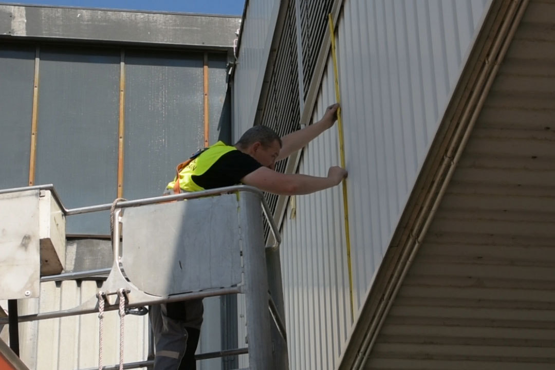 Montagevorbereitung an Hallenfassade aus einer Hubarbeitsbühne heraus